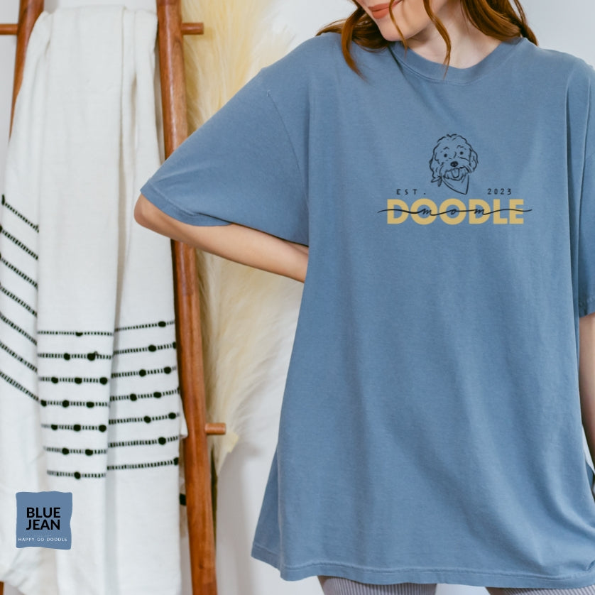Goldendoodle Mom comfort colors t-shirt with Goldendoodle face and words "Doodle Mom Est 2023" in blue jean color