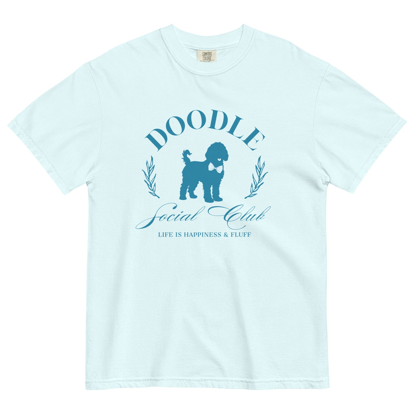This Goldendoodle shirt says, "Doodle Social Club" and the tag line "Live Like You're a Doodle Dog" below a graphic of a Golden Doodle dog wearing a blue bow tie. The design is printed in blue on the front of a light blue Comfort Colors short-sleeve shirt.