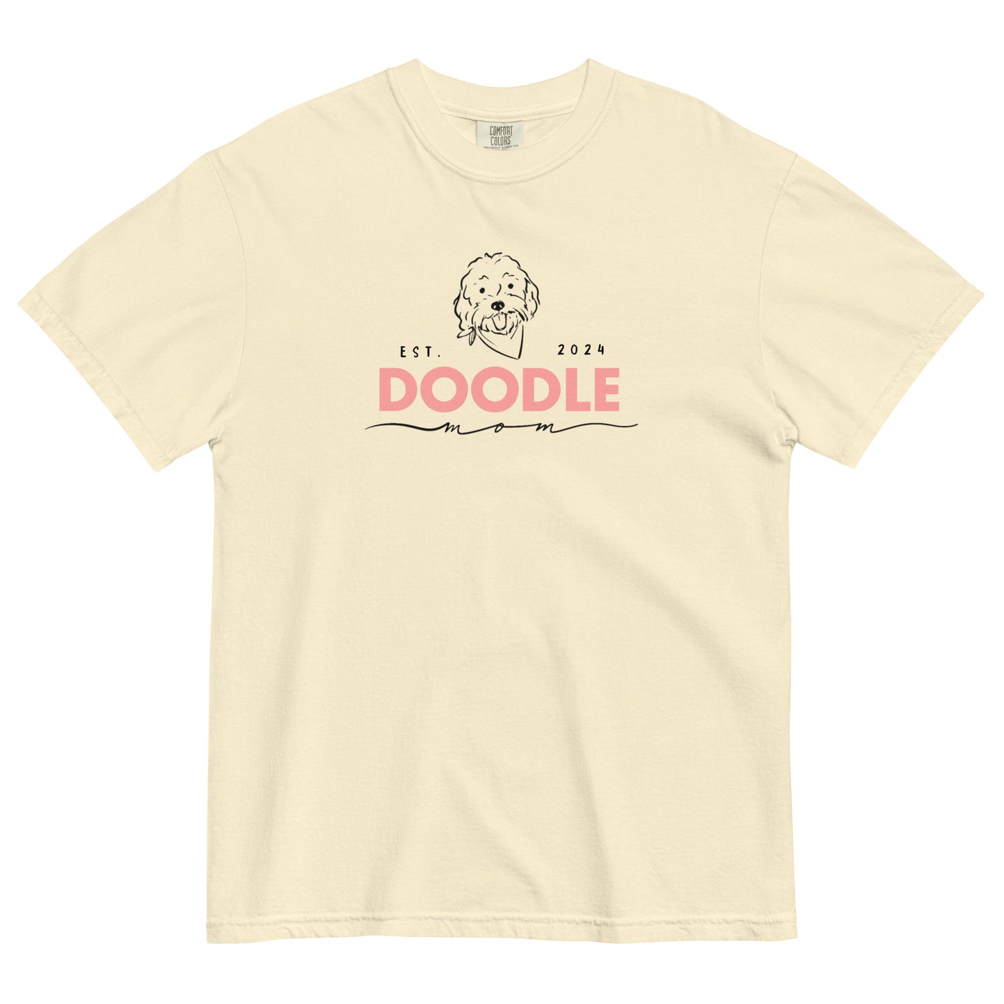 This ivory colored Doodle Mom shirt displays the phrase, "Doodle Mom Est. 2024" with a cute Doodle dog's face printed on the front of a short-sleeve Comfort Colors T-shirt