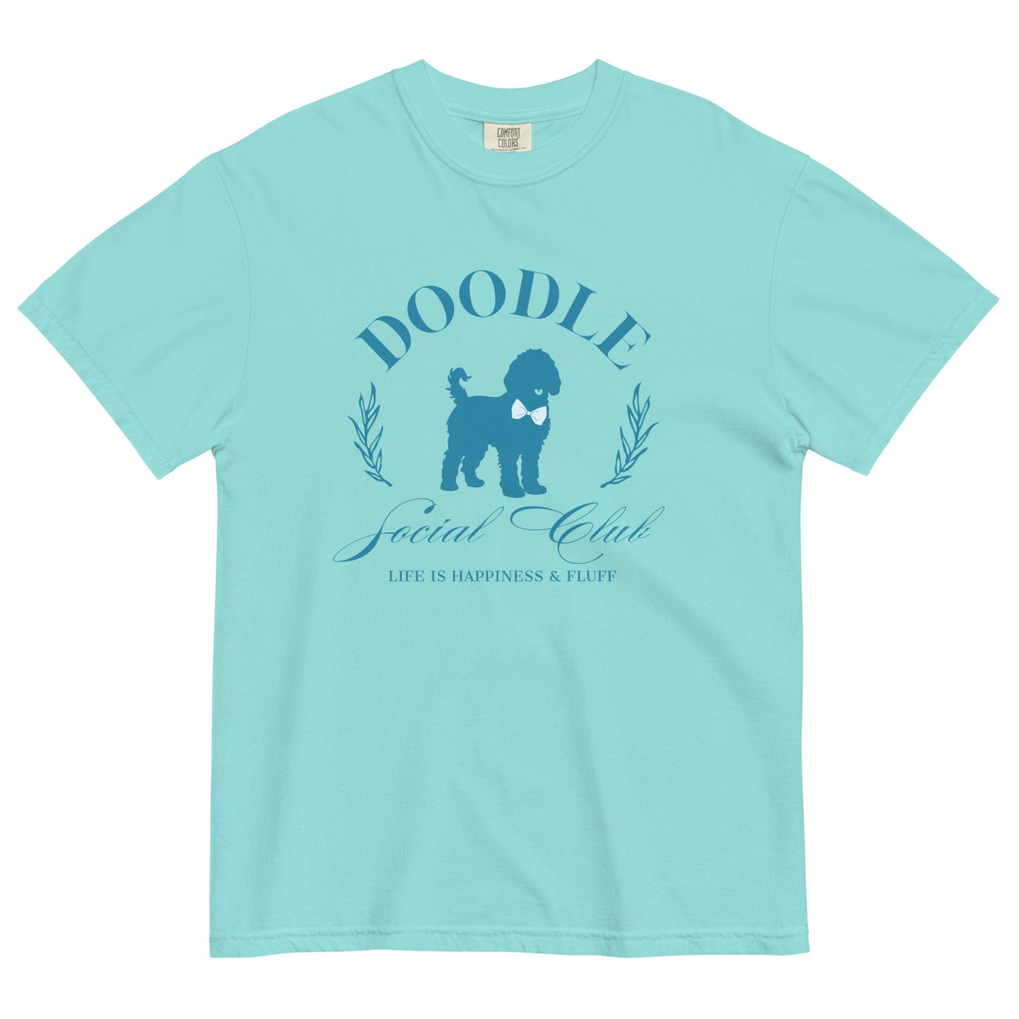 This Goldendoodle shirt displays the phrase, "Doodle Social Club" and the tag line "Live Like You're a Doodle Dog" below a graphic of a Doodle dog wearing a blue bow tie. The design is printed in blue on the front of a teal Comfort Colors short-sleeve T-shirt.