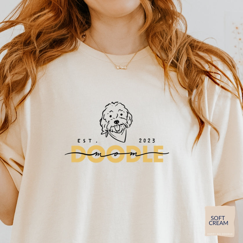 Goldendoodle Mom t-shirt with Goldendoodle face and words "Doodle Mom Est 2023" in soft cream color