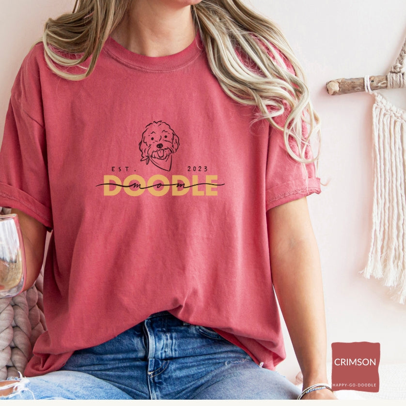 Goldendoodle Mom comfort colors t-shirt with Goldendoodle face and words "Doodle Mom Est 2023" in crimson color