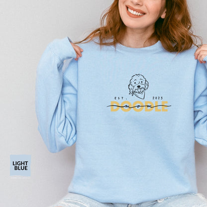 Goldendoodle Mom crew neck sweatshirt with Goldendoodle face and words "Doodle Mom Est 2023" in light blue color