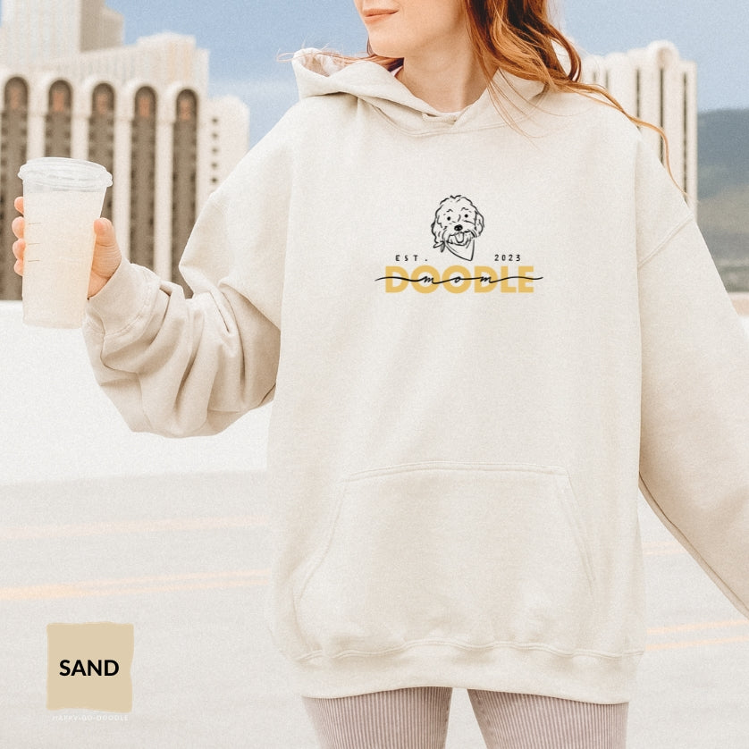 Goldendoodle Mom Hoodie with Goldendoodle face and words "Doodle Mom Est 2023" in sand color